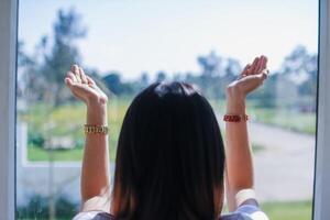 woman raised her hands above her head to ask for mercy from God in accordance with her belief in God in Christianity. back woman raising both hands to ask for blessings from God according to beliefs photo