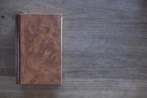 Bible lies on a wooden table after praying to God, which is a Christian religious ritual and belief in the teachings of God. The concept of praying God with the teachings of the Bible and the cross. photo