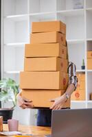 SME business operator is inspecting and packing products into parcel box for delivery company that will come pick up products after participating in online marketing with Application shopping online photo