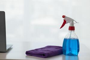 The disinfectant-based cleaning solution is prepared in a spray bottle for easy spraying to clean office interiors and furniture surfaces. Concept of contract Hire a cleaner and spraying disinfectant photo