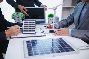 Businessmen, investors and electrical engineers discuss clean energy residential projects help reduce global warming and use clean energy from wind and sunlight. concept clean energy projects photo