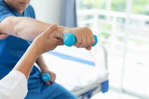 doctor is helping a patient move her muscles after recuperating from a muscle injury and wanting to rehabilitate her to be able to use her normal daily life with continuous physical therapy. photo