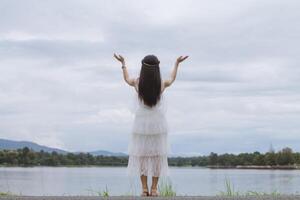 woman raised her hands above her head to ask for mercy from God in accordance with her belief in God in Christianity. back woman raising both hands to ask for blessings from God according to beliefs photo