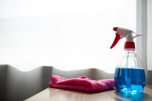 The disinfectant-based cleaning solution is prepared in a spray bottle for easy spraying to clean office interiors and furniture surfaces. Concept of contract Hire a cleaner and spraying disinfectant photo