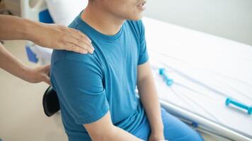 man was admitted for treatment of muscle pain in back of his shoulder due to working hard and causing muscle inflammation. doctor is treating man muscle pain in his back and shoulders due to overwork. photo