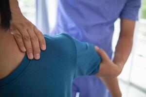 man was admitted for treatment of muscle pain in back of his shoulder due to working hard and causing muscle inflammation. doctor is treating man muscle pain in his back and shoulders due to overwork. photo