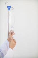 Bottles saline are hung on poles for giving saline patients and passing them through an intravenous line on patient bed. Medical which doctor gives saline solution patient through an intravenous photo