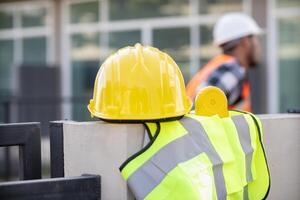 Yellow safety helmet are provided along with reflective vests for workers wear because Yellow safety helmets protect against falling objects during construction and reflective vests provide visibility photo