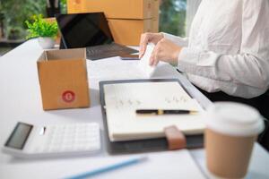 SME business operator is inspecting and packing products into parcel box for delivery company that will come pick up products after participating in online marketing with Application shopping online photo