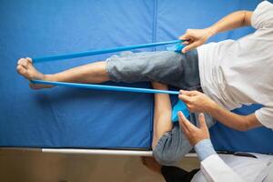 Doctors are examining patient muscle injuries and doing physical therapy for patient to move muscles so they can be used regularly because physical therapy will help strengthen muscles and blood flow. photo