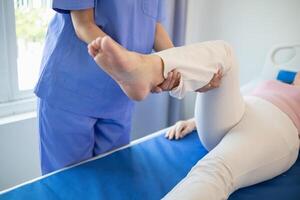 female doctor is helping a patient move her muscles after recuperating from a muscle injury and wanting to rehabilitate her to be able to use her normal daily life with continuous physical therapy. photo