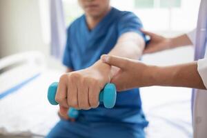 doctor is helping a patient move her muscles after recuperating from a muscle injury and wanting to rehabilitate her to be able to use her normal daily life with continuous physical therapy. photo