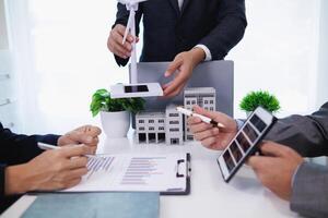 Businessmen, investors and electrical engineers discuss clean energy residential projects help reduce global warming and use clean energy from wind and sunlight. concept clean energy projects photo