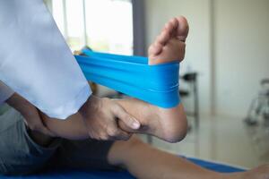 Doctors are examining patient muscle injuries and doing physical therapy for patient to move muscles so they can be used regularly because physical therapy will help strengthen muscles and blood flow. photo