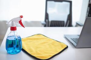 The disinfectant-based cleaning solution is prepared in a spray bottle for easy spraying to clean office interiors and furniture surfaces. Concept of contract Hire a cleaner and spraying disinfectant photo