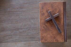 cross is placed on the Bible after prayer to God, which is religious ritual of Christianity and belief in the teachings of God. concept of praying to God with the teachings of the Bible and cross. photo