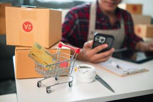 SME business operator is inspecting and packing products into parcel box for delivery company that will come pick up products after participating in online marketing with Application shopping online photo