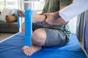 doctor is examining muscle injury and using elastic bands test injury and also help with physical therapy strengthen muscles because physical therapy will help strengthen muscles and help blood flow. photo