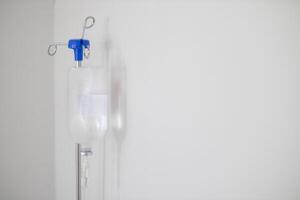 Bottles saline are hung on poles for giving saline patients and passing them through an intravenous line on patient bed. Medical which doctor gives saline solution patient through an intravenous photo
