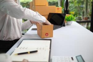 SME business operator is inspecting and packing products into parcel box for delivery company that will come pick up products after participating in online marketing with Application shopping online photo