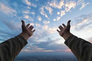 woman raised her hands above her head to ask for mercy from God in accordance with her belief in God in Christianity. back woman raising both hands to ask for blessings from God according to beliefs photo