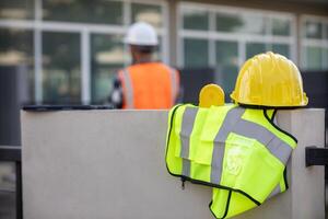 Yellow safety helmet are provided along with reflective vests for workers wear because Yellow safety helmets protect against falling objects during construction and reflective vests provide visibility photo