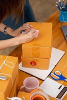SME business operator is inspecting and packing products into parcel box for delivery company that will come pick up products after participating in online marketing with Application shopping online photo