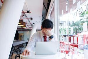 A businessman who is in a state of failure because his investments do not meet his goals lead to stress and headaches. The concept of a headache due to the wrong businessman's investment. photo