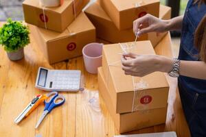 SME business operator is inspecting and packing products into parcel box for delivery company that will come pick up products after participating in online marketing with Application shopping online photo