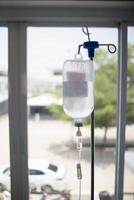 Bottles saline are hung on poles for giving saline patients and passing them through an intravenous line on patient bed. Medical which doctor gives saline solution patient through an intravenous photo