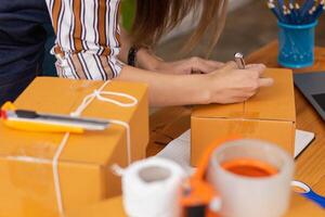 SME business operator is inspecting and packing products into parcel box for delivery company that will come pick up products after participating in online marketing with Application shopping online photo