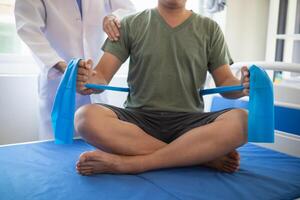 doctor is examining muscle injury and using elastic bands test injury and also help with physical therapy strengthen muscles because physical therapy will help strengthen muscles and help blood flow. photo
