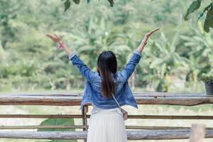 woman raised her hands above her head to ask for mercy from God in accordance with her belief in God in Christianity. back woman raising both hands to ask for blessings from God according to beliefs photo