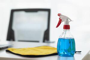 The disinfectant-based cleaning solution is prepared in a spray bottle for easy spraying to clean office interiors and furniture surfaces. Concept of contract Hire a cleaner and spraying disinfectant photo