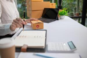 SME business operator is inspecting and packing products into parcel box for delivery company that will come pick up products after participating in online marketing with Application shopping online photo
