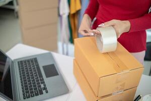 SME business operator is inspecting and packing products into parcel box for delivery company that will come pick up products after participating in online marketing with Application shopping online photo