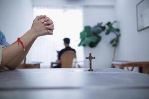 young woman clasped her hands together in prayer asking for forgiveness from God based on her Christian beliefs and faith in God teachings. concept prayer and intercession according beliefs about God photo