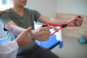 doctor is examining muscle injury and using elastic bands test injury and also help with physical therapy strengthen muscles because physical therapy will help strengthen muscles and help blood flow. photo
