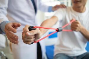 doctor is examining muscle injury and using elastic bands test injury and also help with physical therapy strengthen muscles because physical therapy will help strengthen muscles and help blood flow. photo