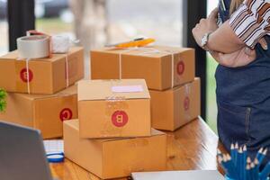 SME business operator is inspecting and packing products into parcel box for delivery company that will come pick up products after participating in online marketing with Application shopping online photo