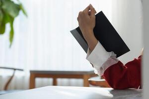 The young woman held a Bible in her hand and tried to learn and understand God teachings from the Bible she held. Concepts of belief and the power of faith in God and teachings from the Bible. photo