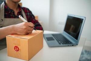 SME business operator is inspecting and packing products into parcel box for delivery company that will come pick up products after participating in online marketing with Application shopping online photo
