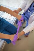 doctor is examining muscle injury and using elastic bands test injury and also help with physical therapy strengthen muscles because physical therapy will help strengthen muscles and help blood flow. photo