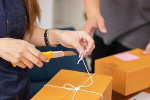 SME business operator is inspecting and packing products into parcel box for delivery company that will come pick up products after participating in online marketing with Application shopping online photo