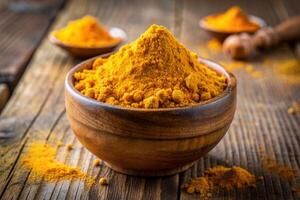tumeric powder in a wooden bowl on a rustic wooden table photo