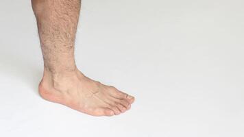 Adult man foot in closeup against a white background with space for text, showing inner ankle view. photo