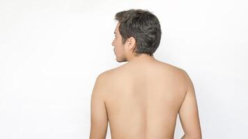 Back view of a shirtless young adult man, looking to the left, with space for text on the left, against a white background. photo