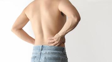 Shirtless man suffering from waist and back pain, with a white background and space for text photo