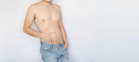 Man displaying his torso with blue jeans, white background, and space for text. Sexuality, masculinity, intimate areas. photo