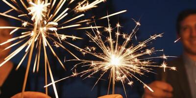 People holding a lit Sparkler. The soft light illuminates them. A warm New Year's atmosphere in the dark. photo